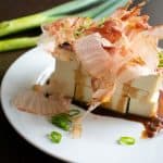 japanese tofu salad with bonito flakes on white round plate