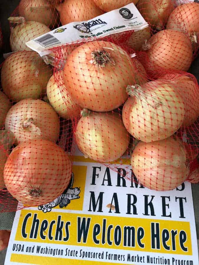 walla walla onions in red mesh bags at farmers market