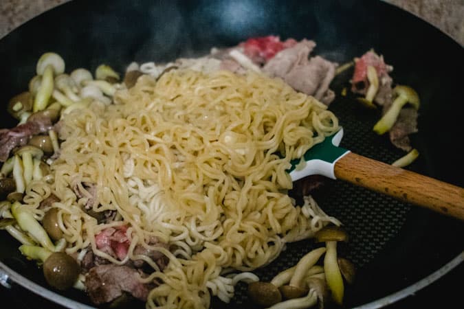 cooked ramen noodles in nonstick pan with spatula