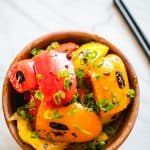 Healthy bell peppers with vegan black bean sauce in wood bowl with black chopsticks on the side.
