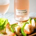 Shrimp and avocado salad in front of a bottle and glass of Gerard Bertrand rose