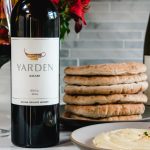Yarden wines with a stack of pita bread and hummus