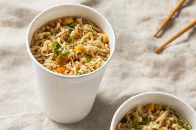 white cup of instant ramen on a beige linen