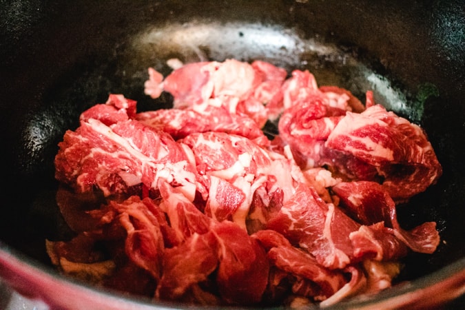 sliced beef in a black pot