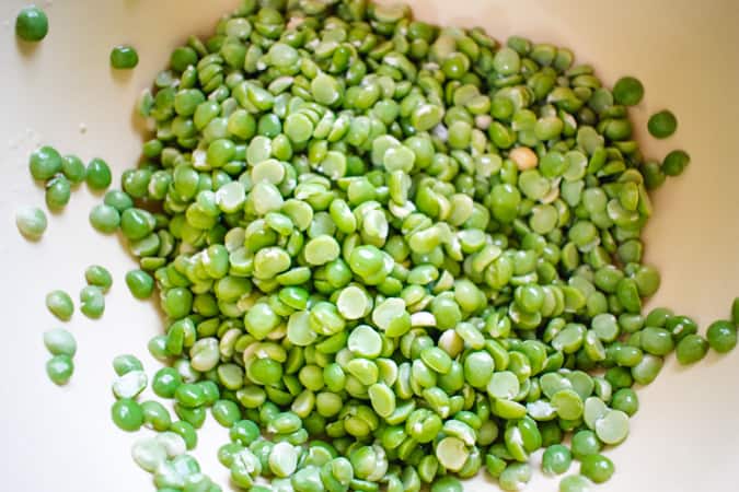 soaked green split peas in a yellow bowl