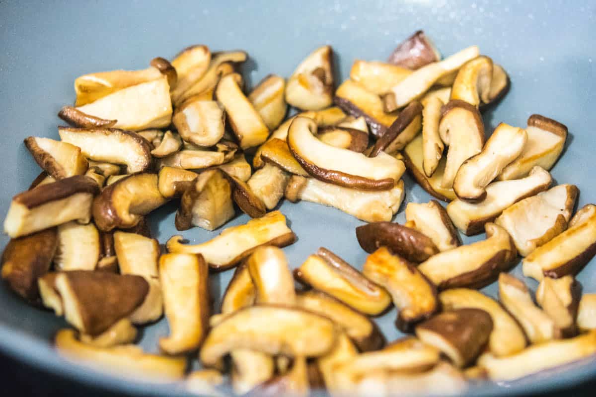 cooked shiitake mushrooms with soy sauce in a gray wok
