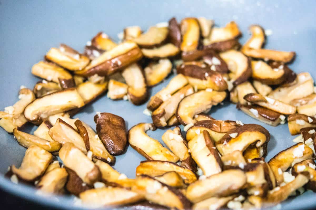 shiitake mushrooms with garlic in a gray wok